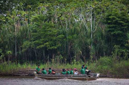 Healthcare workers on the way to visit a community deep in the Peruvian Amazon.: Healthcare workers on the way to visit a community deep in the Peruvian Amazon. The journey from Iquitos to the village takes two days by canoe.
